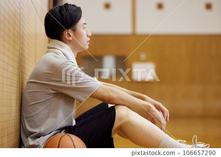 Japanese male university student practicing basketball in the gymnasium 106657290