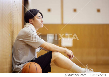 Japanese male university student practicing basketball in the gymnasium 106657291