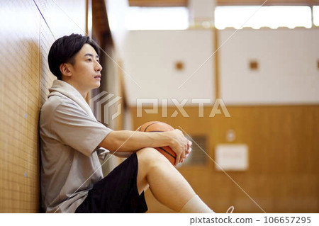 Japanese male university student practicing basketball in the gymnasium 106657295