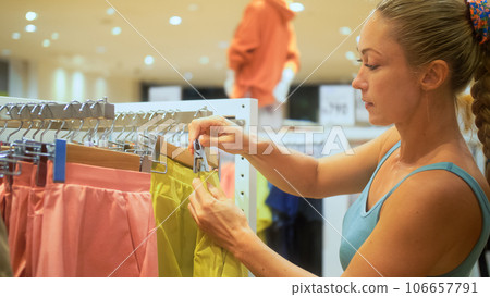 Satisfied customer client girl shopper buyer shopaholic buy sale clothes at shopping mall store. Pretty girl customer choose sports clothes at shopping mall store. Concept shopping in clothes store. Satisfied customer client girl shopper buyer shopaholic buy sale clothes at shopping mall store. Pretty girl customer choose sports clothes at shopping mall store. Concept shopping in clothes store. 106657791