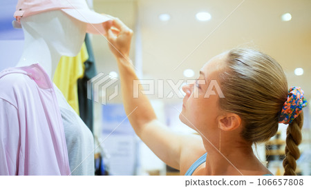 Beautiful woman shopper customer is looking and buying colorful casual clothes in clothing store.Happy smile confident client buying or watching casual modern outerwear or underwear in clothing store. Beautiful woman shopper customer is looking and buying colorful casual clothes in clothing store.Happy smile confident client buying or watching casual modern outerwear or underwear in clothing store. 106657808