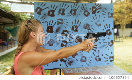 Woman shoots at shooting range with pneumatic gun. Outdoors entertainment for tourists in Thailand.Active leisure on vacation, traveling in Asia.Practice in shooting gallery safe legal pistol weapons. Woman shoots at shooting range with pneumatic gun. Outdoors entertainment for tourists in Thailand.Active leisure on vacation, traveling in Asia.Practice in shooting gallery safe legal pistol weapons. 106657824