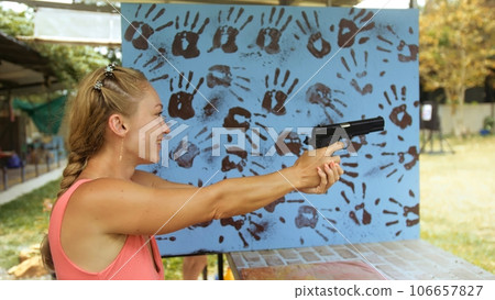 Woman shoots at shooting range with pneumatic gun. Outdoors entertainment for tourists in Thailand.Active leisure on vacation, traveling in Asia.Practice in shooting gallery safe legal pistol weapons. Woman shoots at shooting range with pneumatic gun. Outdoors entertainment for tourists in Thailand.Active leisure on vacation, traveling in Asia.Practice in shooting gallery safe legal pistol weapons. 106657827