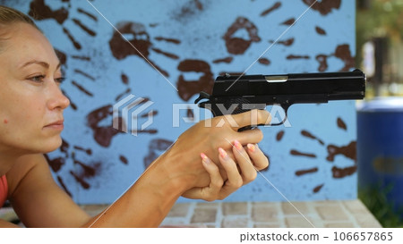 Woman shoots at shooting range with pneumatic gun. Outdoors entertainment for tourists in Thailand.Active leisure on vacation, traveling in Asia.Practice in shooting gallery safe legal pistol weapons. Woman shoots at shooting range with pneumatic gun. Outdoors entertainment for tourists in Thailand.Active leisure on vacation, traveling in Asia.Practice in shooting gallery safe legal pistol weapons. 106657865