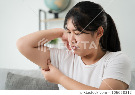 Close up of Chubby woman pinching upper arm fat. weight loss concept. 106658312