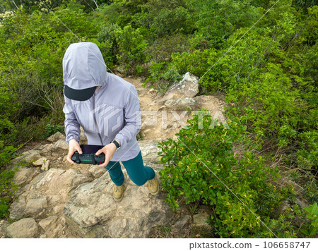 People remote contrlling a flying drone in spring forest People remote contrlling a flying drone in spring forest 106658747