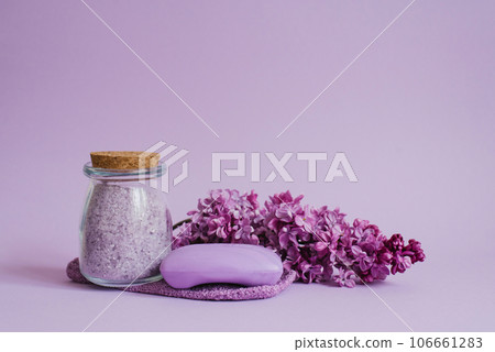 Spa setting with natural soap, sea salt, washcloth glove for body care, lilac flowers on a light background with copy space 106661283