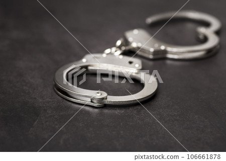The metal handcuffs on black background. Handcuff or shackle. Police handcuffs The metal handcuffs on black background. Handcuff or shackle. Police handcuffs 106661878