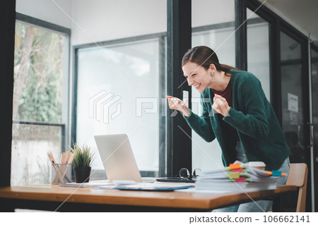 Businesswoman happy and cheerful for successful on project via laptop in office space. 106662141