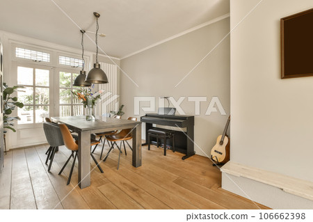 a dining room with wood flooring and white walls there is a piano on the table in front of the window a dining room with wood flooring and white walls there is a piano on the table in front of the window 106662398