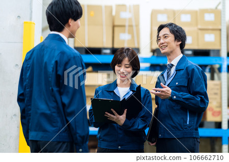 Male and female employees wearing work clothes working at a distribution center 106662710