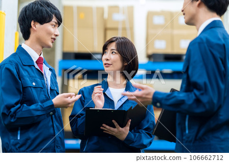 Male and female employees wearing work clothes working at a distribution center 106662712