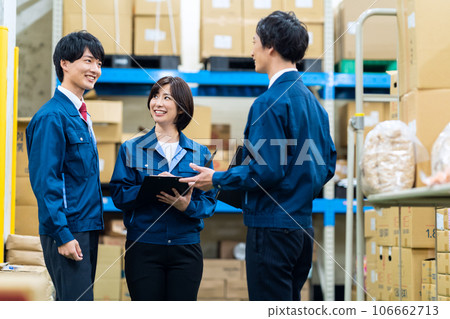 Male and female employees wearing work clothes working at a distribution center 106662713