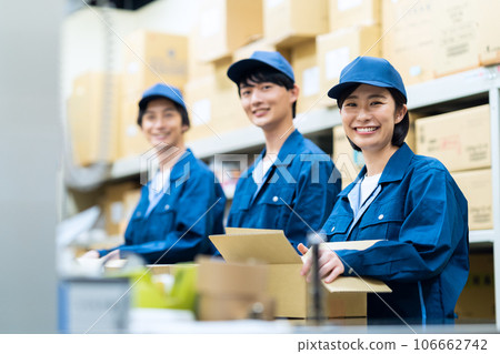 Young male and female workers wearing work clothes working at a distribution center Young male and female workers wearing work clothes working at a distribution center 106662742