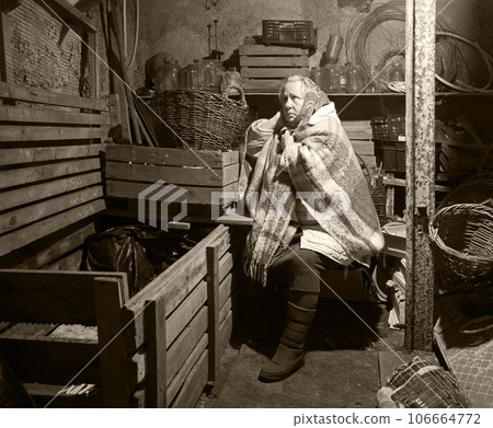 A woman hides in a cellar from shelling A woman hides in a cellar from shelling 106664772