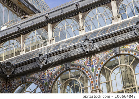 Crystal Palace (Palacio de cristal) in Retiro Park,Madrid, Spain. Is the main attraction of the park (built in 1887 by the architect Velazquez Bosco). Detail of the crystal palace. Crystal Palace (Palacio de cristal) in Retiro Park,Madrid, Spain. Is the main attraction of the park (built in 1887 by the architect Velazquez Bosco). Detail of the crystal palace. 106664842