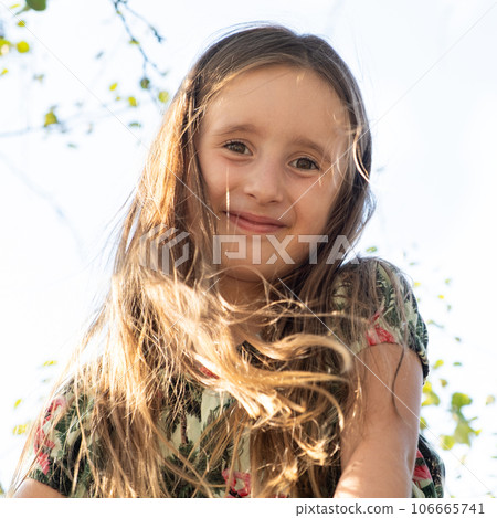 Portrait of a 5 or 6-year-old girl with flowing long hair in the wind 106665741