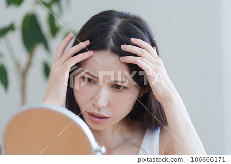 一個女人檢查她的髮際線 106666171