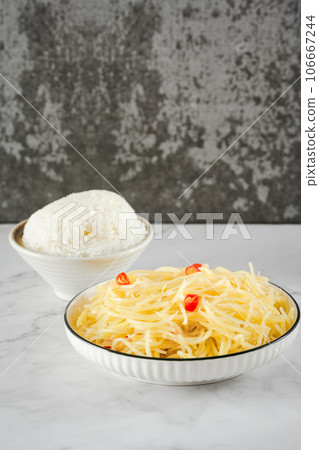Stir-fried potato shreds and rice on a stone slab table. 106667244