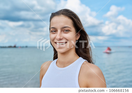 Portrait of smiling teenage girl outdoor on sea background Portrait of smiling teenage girl outdoor on sea background 106668156