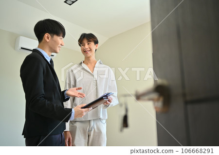 Male real estate agent offering home ownership and life insurance to client. Real estate mortgage and property investment concept Male real estate agent offering home ownership and life insurance to client. Real estate mortgage and property investment concept 106668291