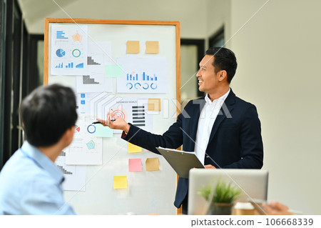 Professional businessman giving presentation, explaining report investment graph chart data in meeting room 106668339