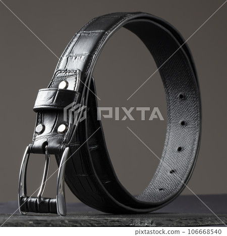 Black leather belt on a dark background. Men's belt. 106668540