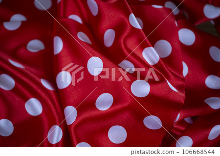 Red silk fabric with large white polka dots. Polka dot background. Red silk fabric with large white polka dots. Polka dot background. 106668544