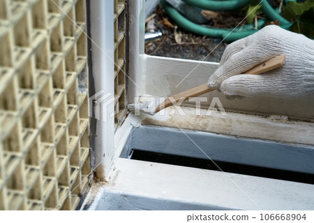 Craftsman painting a rusted iron gate Painting work 01 106668904