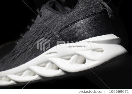 Black fabric sneakers with a white sole on a black background. 106669671