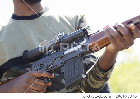 Dragunov sniper rifle in male hands. Part of a military weapon. Dragunov sniper rifle in male hands. Part of a military weapon. 106670370