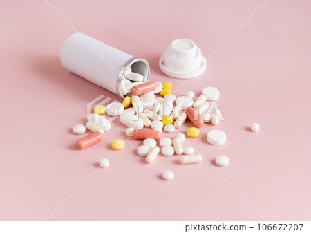 Mix of medical capsules and pills with a bottle on light pink top view. Medicinal treatment Mix of medical capsules and pills with a bottle on light pink top view. Medicinal treatment 106672207