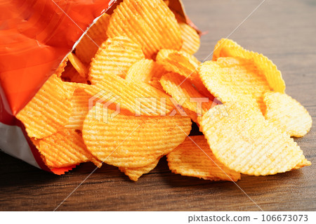 Potato chips in open bag, delicious BBQ seasoning spicy for crips, thin slice deep fried snack fast food. 106673073
