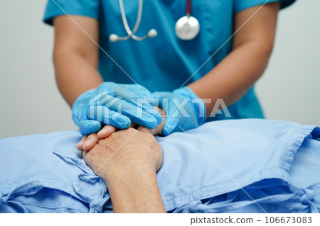 Doctor holding hands Asian elderly woman patient, help and care in hospital. Doctor holding hands Asian elderly woman patient, help and care in hospital. 106673083