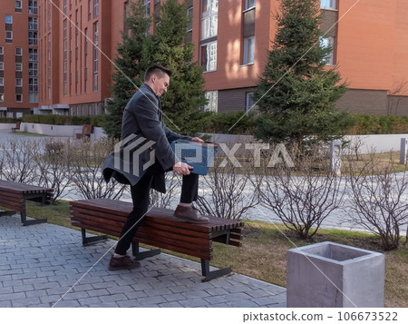 Caucasian man freaks out and breaks laptop outdoors. Caucasian man freaks out and breaks laptop outdoors. 106673522