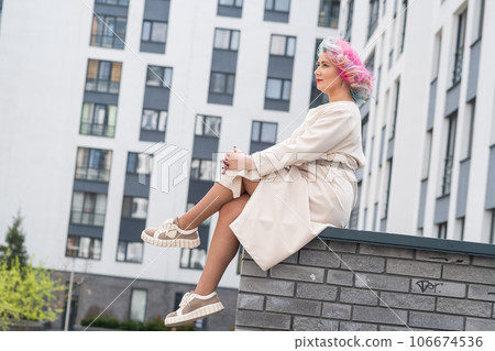Portrait of a middle-aged woman with multi-colored hair walks on the streets of the city. 106674536