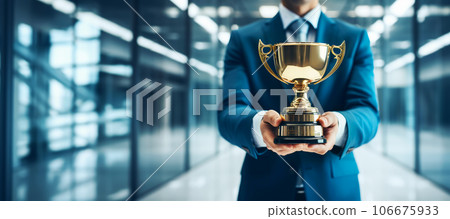 Successful business man holding golden cup trophy close-up. Success and championship leader concept, banner format 106675933