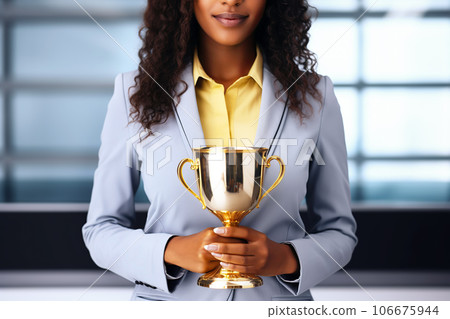 Successful and beautiful african american business woman holding golden cup trophy. Success and championship leader concept 106675944