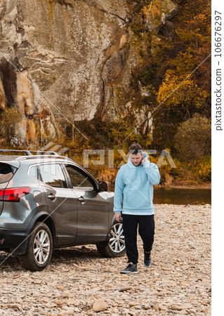 man at the rocky beach in mountain river near car man at the rocky beach in mountain river near car 106676297