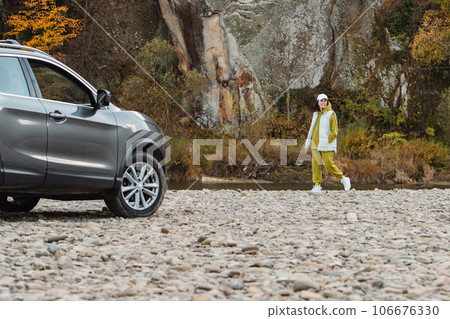 happy woman at rocky beach near suv car road trip concept 106676330