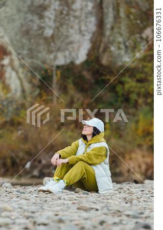 stylish woman sitting at rocky beach stylish woman sitting at rocky beach 106676331