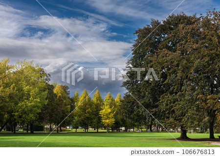 Calm Fall Season. Beautiful Landscape With Road In Autumn Forest. Maples And Birch Trees With Green, Yellow And Orange Leaves And Footpath In The Woodland In Sunny Day 106676813