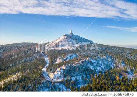 Jested mountain with modern hotel and TV transmitter on the top, Liberec, Czech Republic. Sunny winter day with snowy landscape. Aerial view from drone. Jested mountain with modern hotel and TV transmitter on the top, Liberec, Czech Republic. Sunny winter day with snowy landscape. Aerial view from drone. 106676976