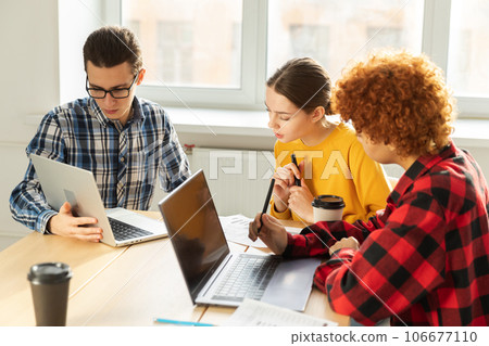 Teamwork brainstorm. Diverse colleagues working together discuss financial statistics. Group of happy young modern people sitting in creative office discussing business. Young professional team 106677110