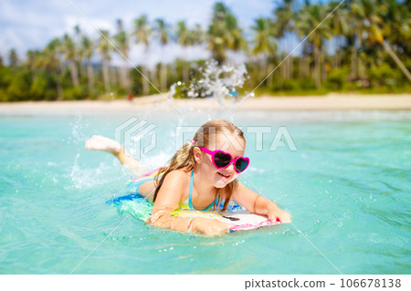 Kids surf on tropical beach. Vacation with child. 106678138