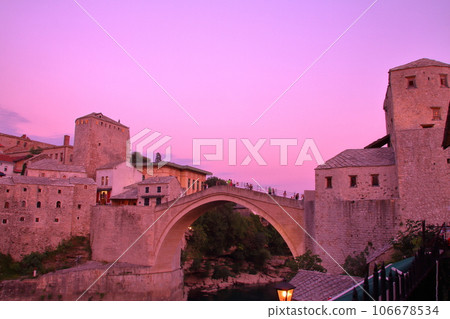 Mostar, Bosnia and Herzegovina, Southern Europe - Sunset view of Stari Most, a world cultural heritage bridge spanning the Neretva River, and the old town Mostar, Bosnia and Herzegovina, Southern Europe - Sunset view of Stari Most, a world cultural heritage bridge spanning the Neretva River, and the old town 106678534