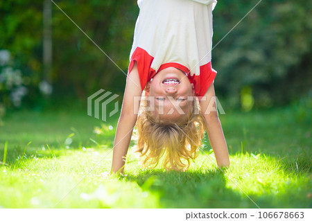 Little boy hanging upside down. Handstand exercise 106678663
