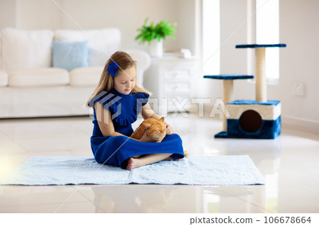 Child playing with cat at home. Kids and pets. 106678664