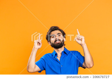 Young man showing thumbs up and pointing at left on blank space, place for your advertisement logo 106678727