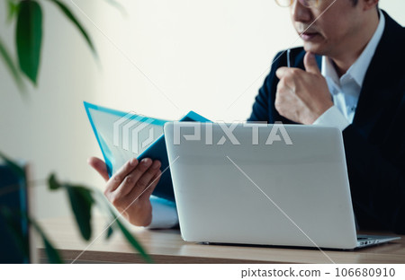 Businessman worried about looking at documents Businessman worried about looking at documents 106680910
